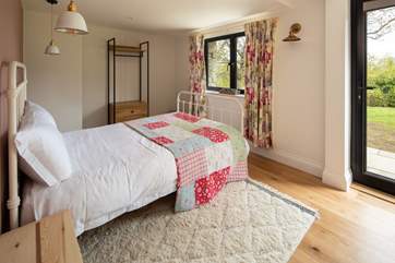 Bedroom two offers direct access onto the patio and sprawling lawn beyond.