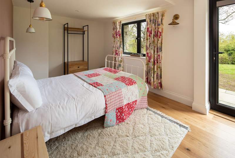 Bedroom two offers direct access onto the patio and sprawling lawn beyond.