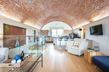 The stunning living-room with kitchen and dining area is both modern and spacious.
