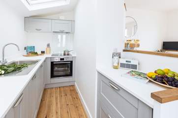The small but perfectly formed kitchen, two steps lead up to the sitting-area.