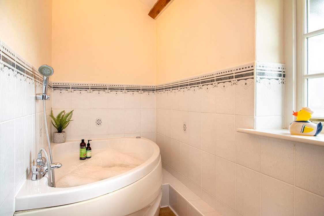 The family bathroom has the luxury of a spa bath - so lie back and relax.