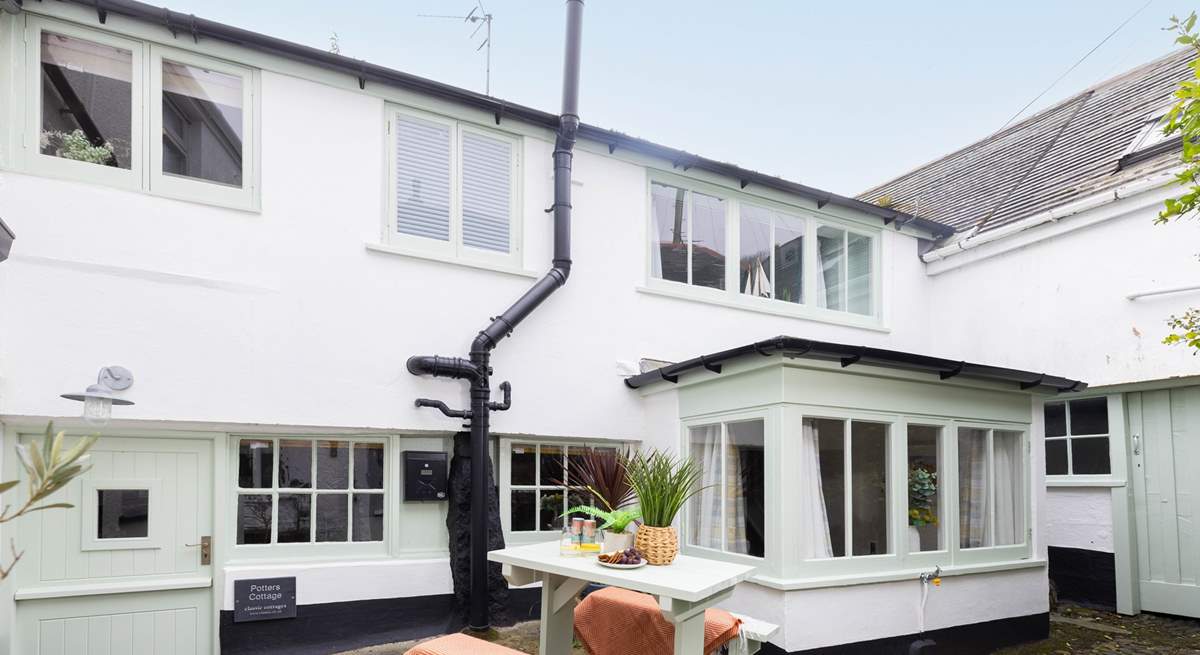 Behind the bay window is the outhouse, where there is a washing machine. Please note,  Two steep steps lead down from the shared courtyard to the stable door. 