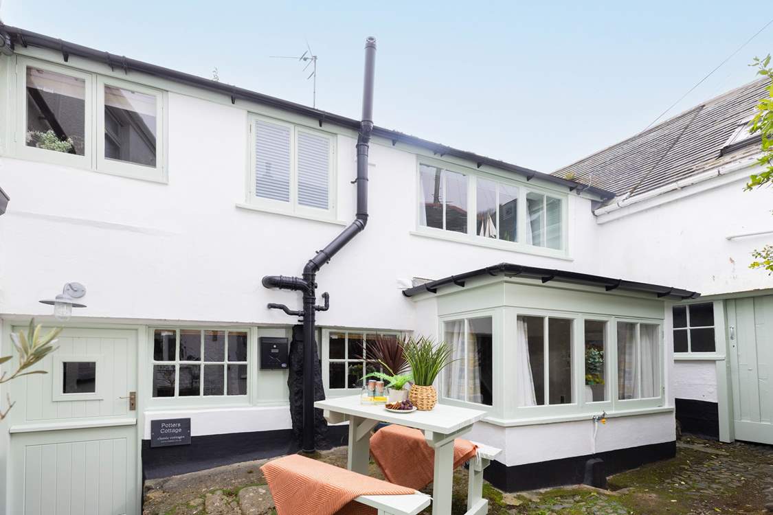 Behind the bay window is the outhouse, where there is a washing machine. Please note,  two steep steps lead down from the shared courtyard to the stable front door.
