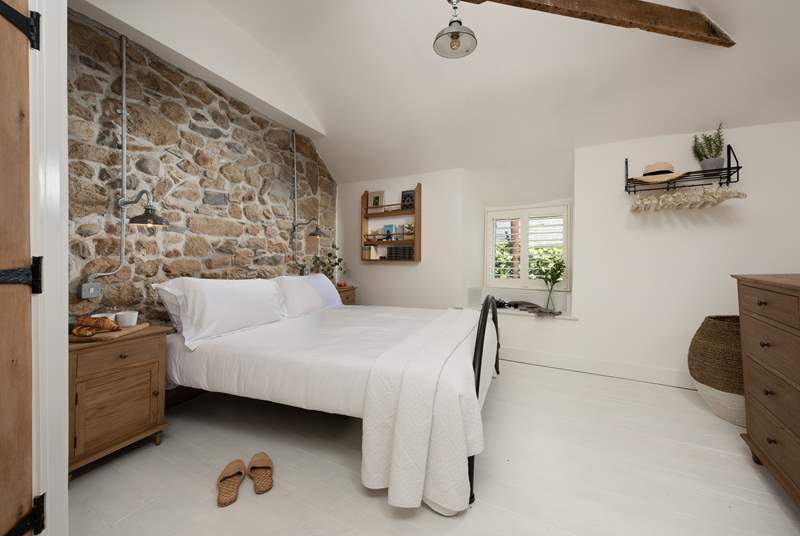 The gorgeous bedroom is tastefully decorated to complement the original stone walls