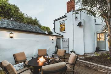 This wonderful Jamie Oliver outdoor table has a fire-pit in the centre.