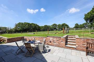 The patio at the rear of Walnut Barn has a lovely sunny aspect and overlooks nearby fields and woodland.