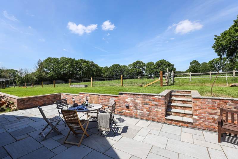 The patio at the rear of Walnut Barn has a lovely sunny aspect and overlooks nearby fields and woodland.