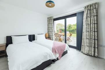 The twin bedroom on the ground floor has access to the gardens through the patio doors, the perfect place for morning coffee.