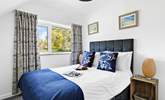 Bedroom 4 has a double bed, luxurious bedding and a garden view. - Thumbnail Image