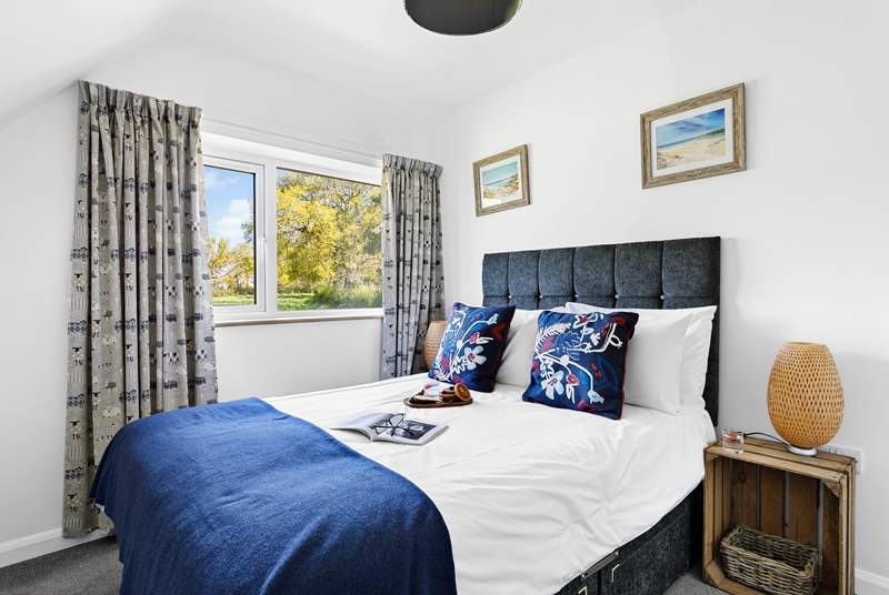 Bedroom 4 has a double bed, luxurious bedding and a garden view.