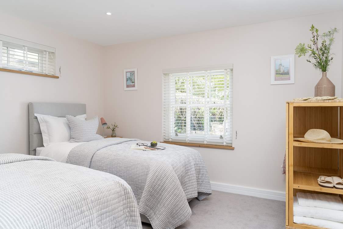 The second bedroom has two luxurious single beds.