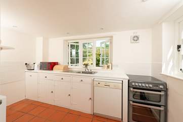 The farmhouse-style kitchen is split into two areas, with plenty of storage and worktop space in its totality.