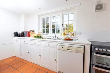 The farmhouse-style kitchen is split into two areas, with plenty of storage and worktop space in its totality.