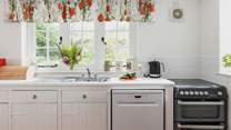 The farmhouse-style kitchen is split into two areas, with plenty of storage and worktop space in its totality.