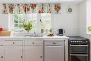 The farmhouse-style kitchen is split into two areas, with plenty of storage and worktop space in its totality.