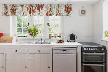 The farmhouse-style kitchen is split into two areas, with plenty of storage and worktop space in its totality.