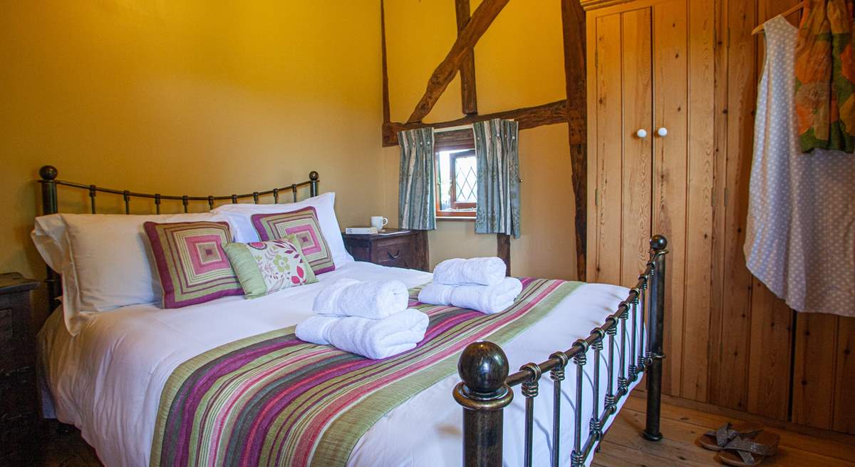 The ground floor bedroom is full of character with high sloping ceilings and gorgeous linens. 