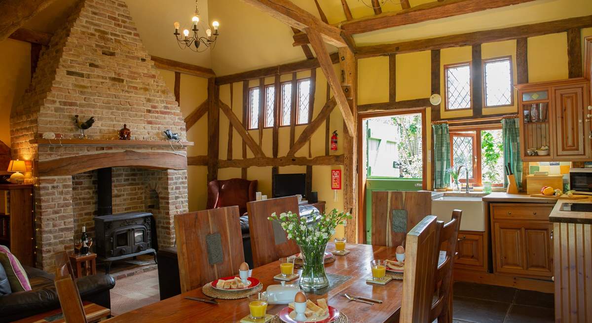 The open plan living/dining-room with a full kitchen area and stone floors throughout.