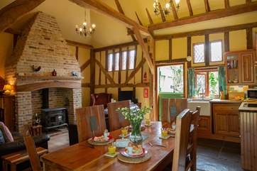 The open plan living/dining-room with a full kitchen area and stone floors throughout.