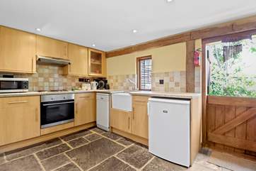 The kitchen with lovely Butler sink and stable-door is complete with a dishwasher, microwave and a Dolce Gusto coffee machine.