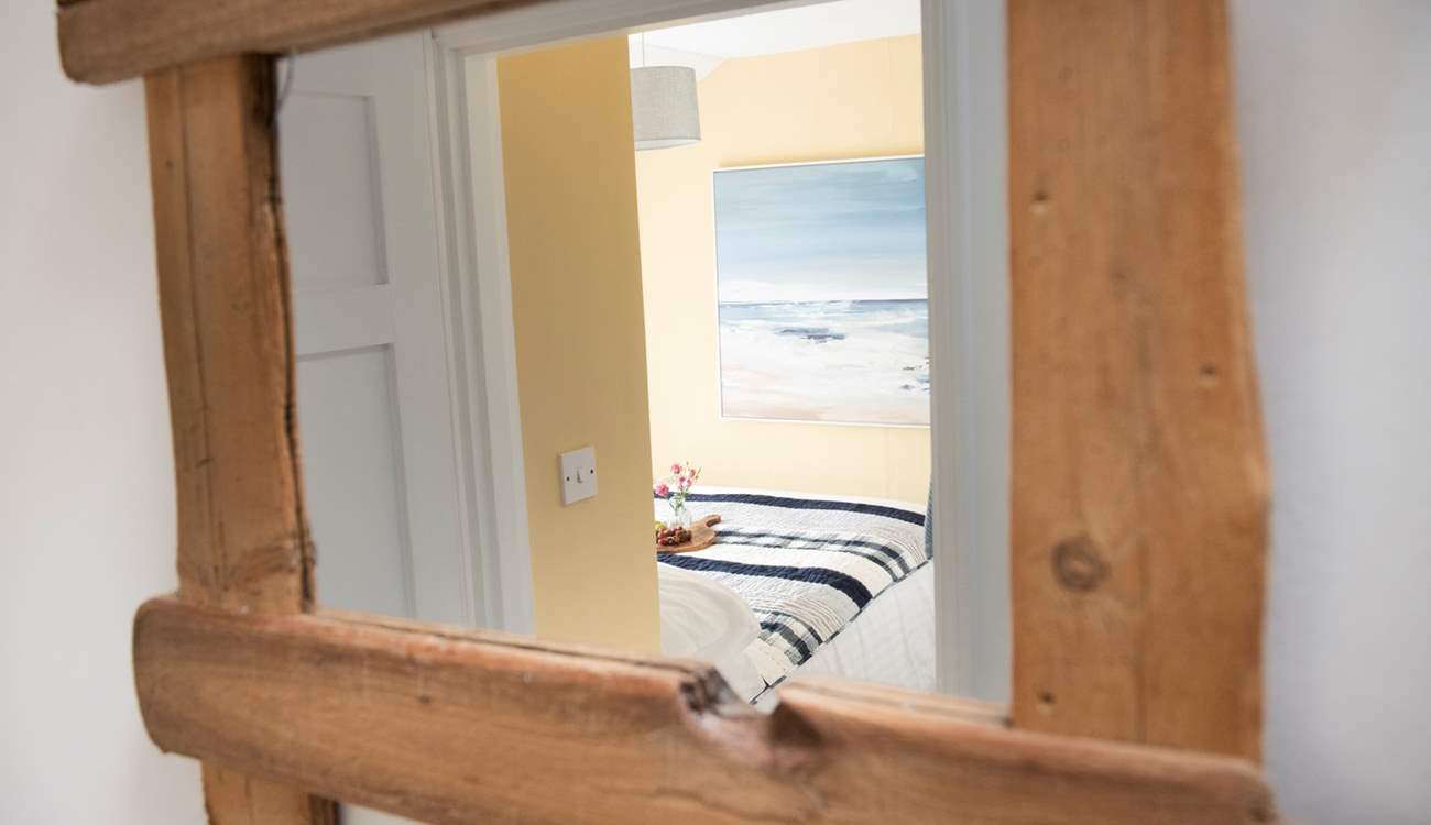 The reclaimed wooden mirror frames the bedroom perfectly.