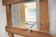 The reclaimed wooden mirror frames the bedroom perfectly.