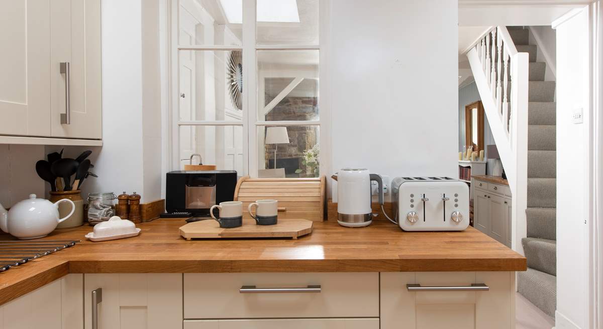 The kitchen is located at the rear of the property. The stairs are narrow and steep, typical of character Cornish cottages. 