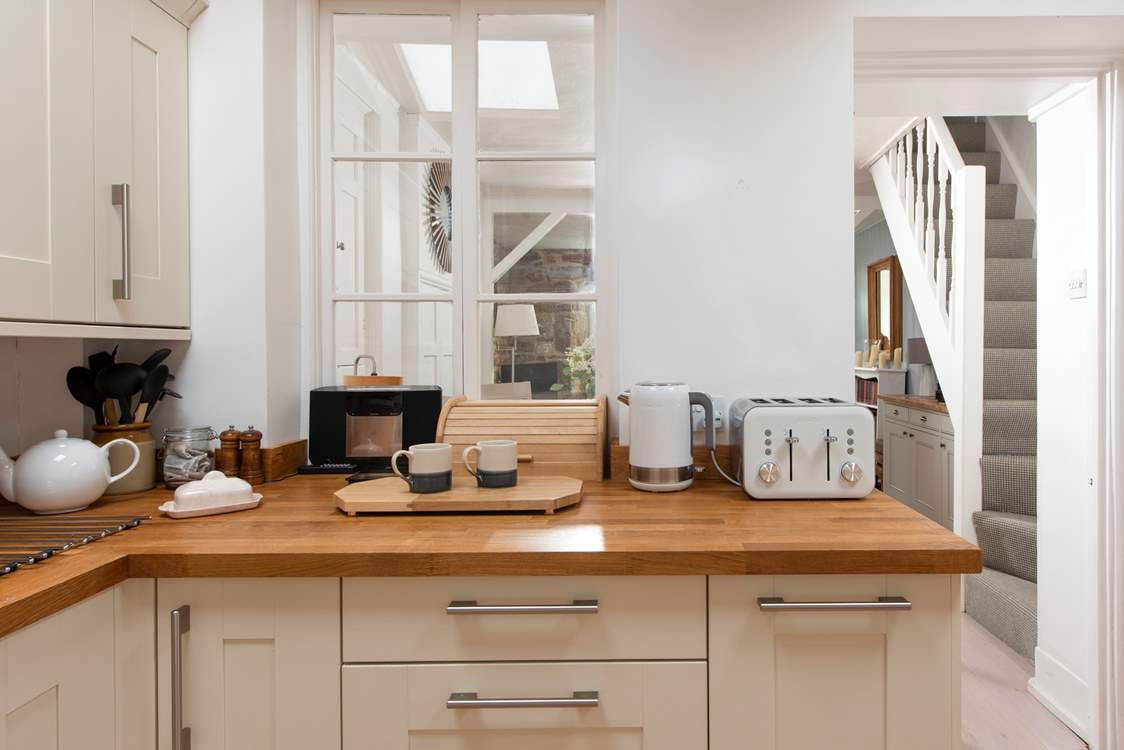 The kitchen is located at the rear of the property. The stairs are narrow and steep, typical of character Cornish cottages.
