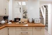 The kitchen is located at the rear of the property. The stairs are narrow and steep, typical of character Cornish cottages.