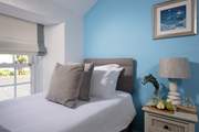 Pretty pastel shades await in the twin bedroom.