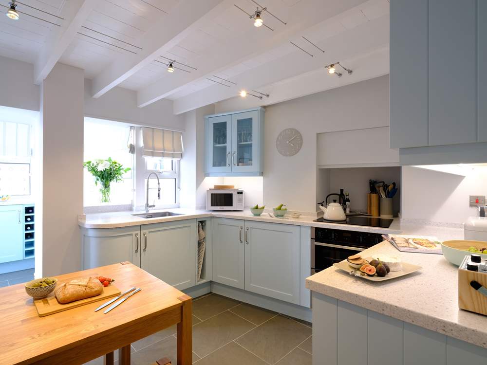The kitchen is presented in stylish pastel tones.