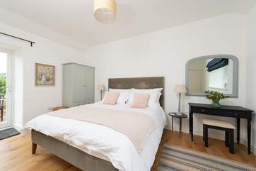 Calming colours in the main bedroom ensure relaxation and there is even a door out to the patio - a perfect spot for morning coffee.