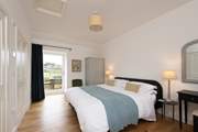 Calming colours in the main bedroom ensure relaxation and there is even a door out to the patio - a perfect spot for morning coffee.