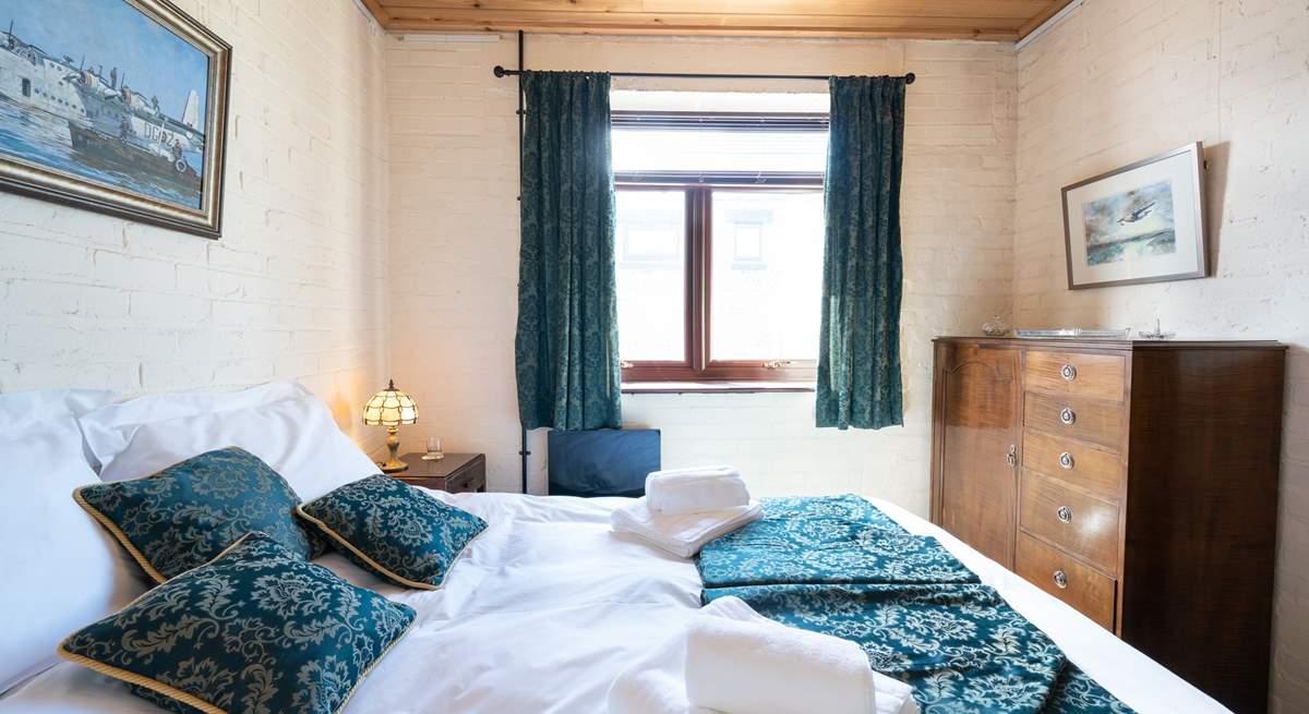 Fluffy white towels and crisp white linen in this charming 1940s bedroom.