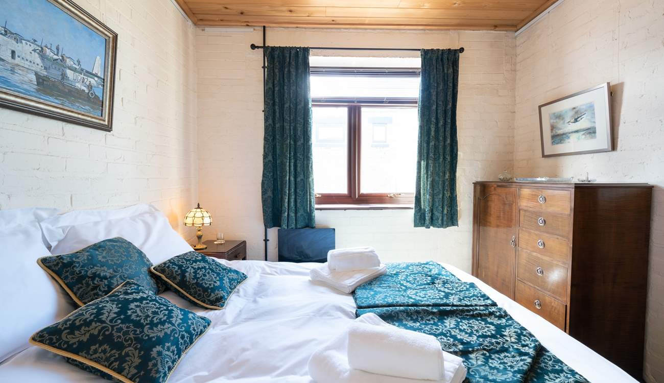 Fluffy white towels and crisp white linen in this charming 1940s bedroom.