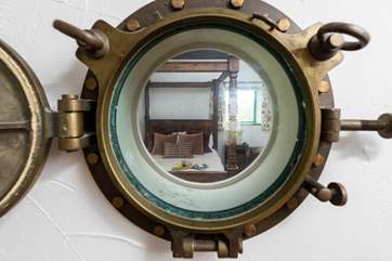 The lovely bedroom, viewed through the fabulous porthole from the living-room.