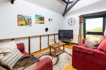 The open plan living-room at Braddon Cottage is light and bright with a double height ceiling and exposed beams.