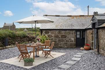 Stable-doors lead out from the open plan living-room onto the gorgeous, enclosed patio, sheltered by an old Cornish hedge.
