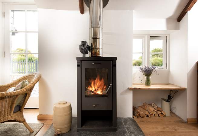 The sitting-area is flooded with light and has a comfy sofa and preloved rocking chair basking in the toasty warmth of the wood-burner.