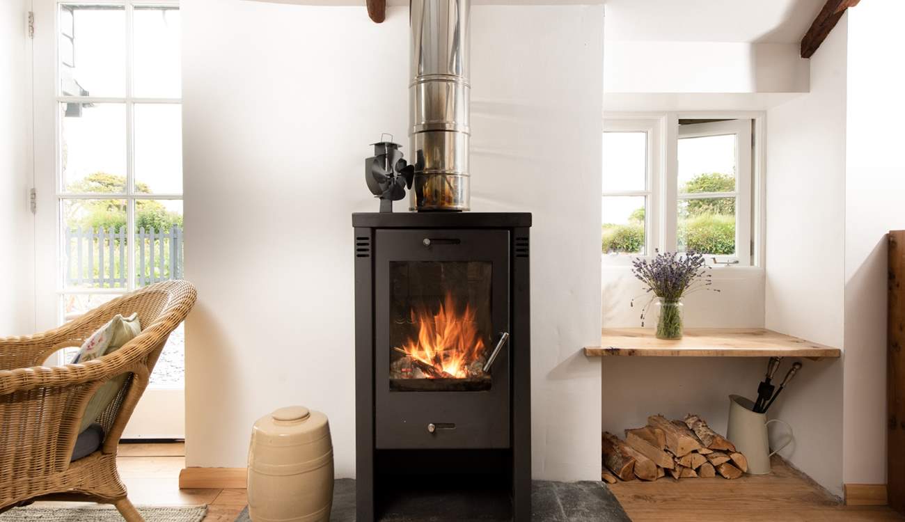 The sitting-area is flooded with light and has a comfy sofa and preloved rocking chair basking in the toasty warmth of the wood-burner.