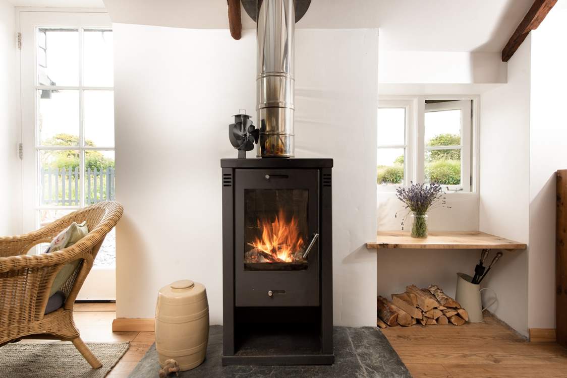The sitting-area is flooded with light and has a comfy sofa and preloved rocking chair basking in the toasty warmth of the wood-burner.