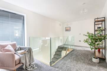 The landing at the top of the stairs with a cosy chair perfect for reading your book in.