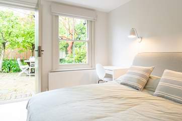 The first bedroom located on the lower ground floor, opens up to the enclosed patio area.