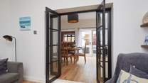 View through the open doors to the welcoming dining-room, kitchen and outdoor patio-area.
