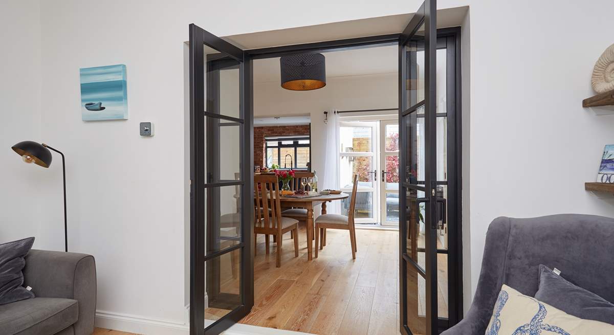 View through the open doors to the welcoming dining room, kitchen and outdoor patio area.