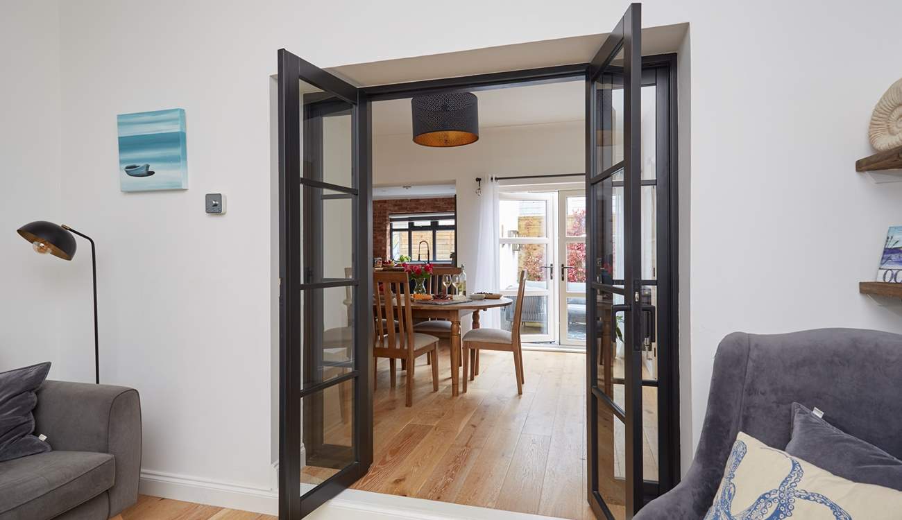 View through the open doors to the welcoming dining-room, kitchen and outdoor patio-area.