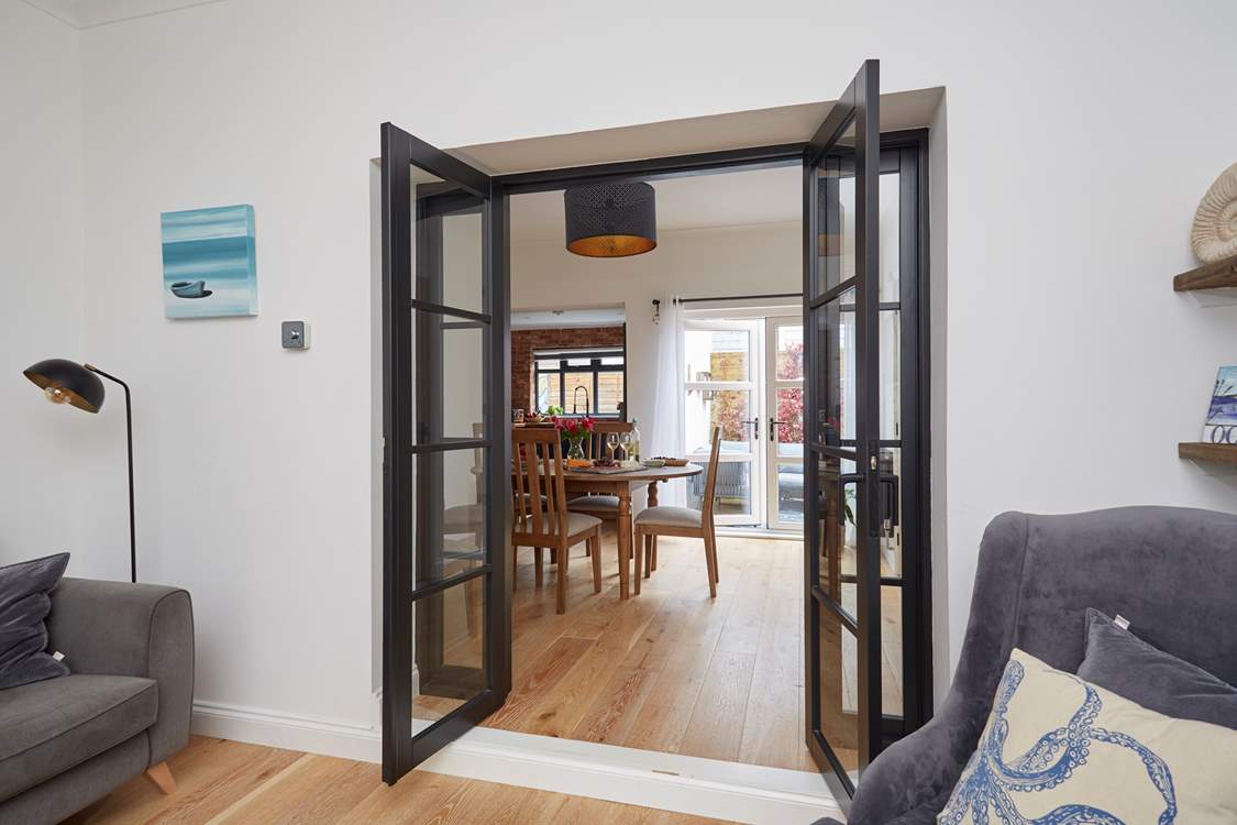 View through the open doors to the welcoming dining room, kitchen and outdoor patio area.