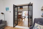 View through the open doors to the welcoming dining room, kitchen and outdoor patio area.