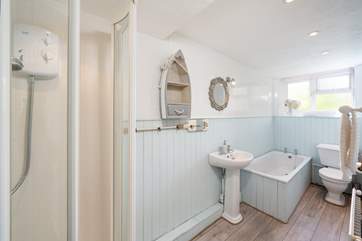 The bathroom has a shower and a bath.
