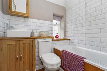 The bathroom has a bath with fitted shower.